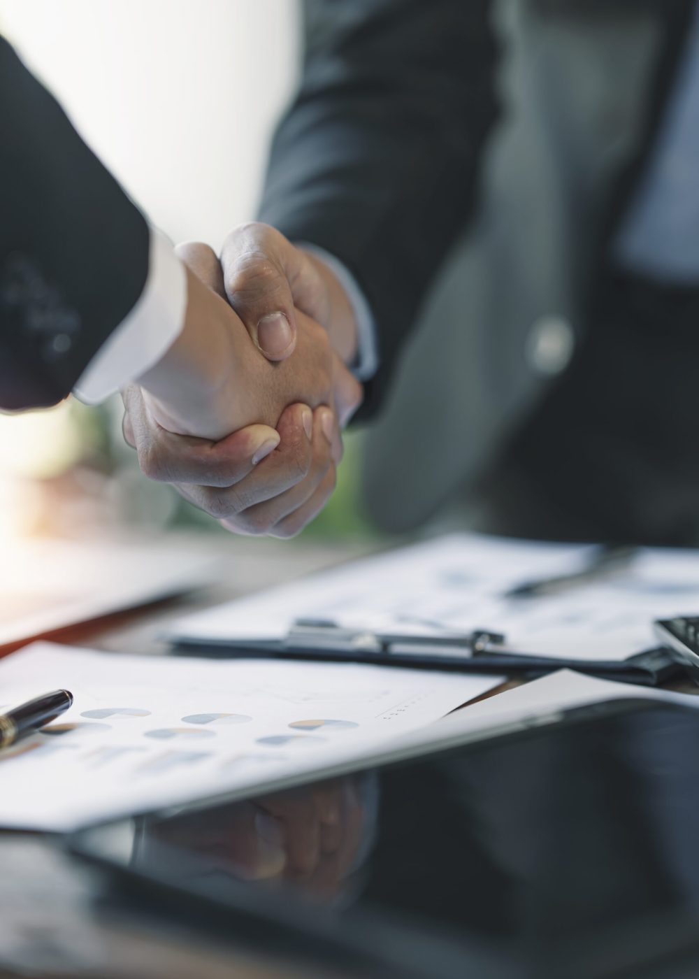 Business partnership meeting concept. businessmans handshake. Successful businessmen handshaking after good deal. Vertical, blurred background