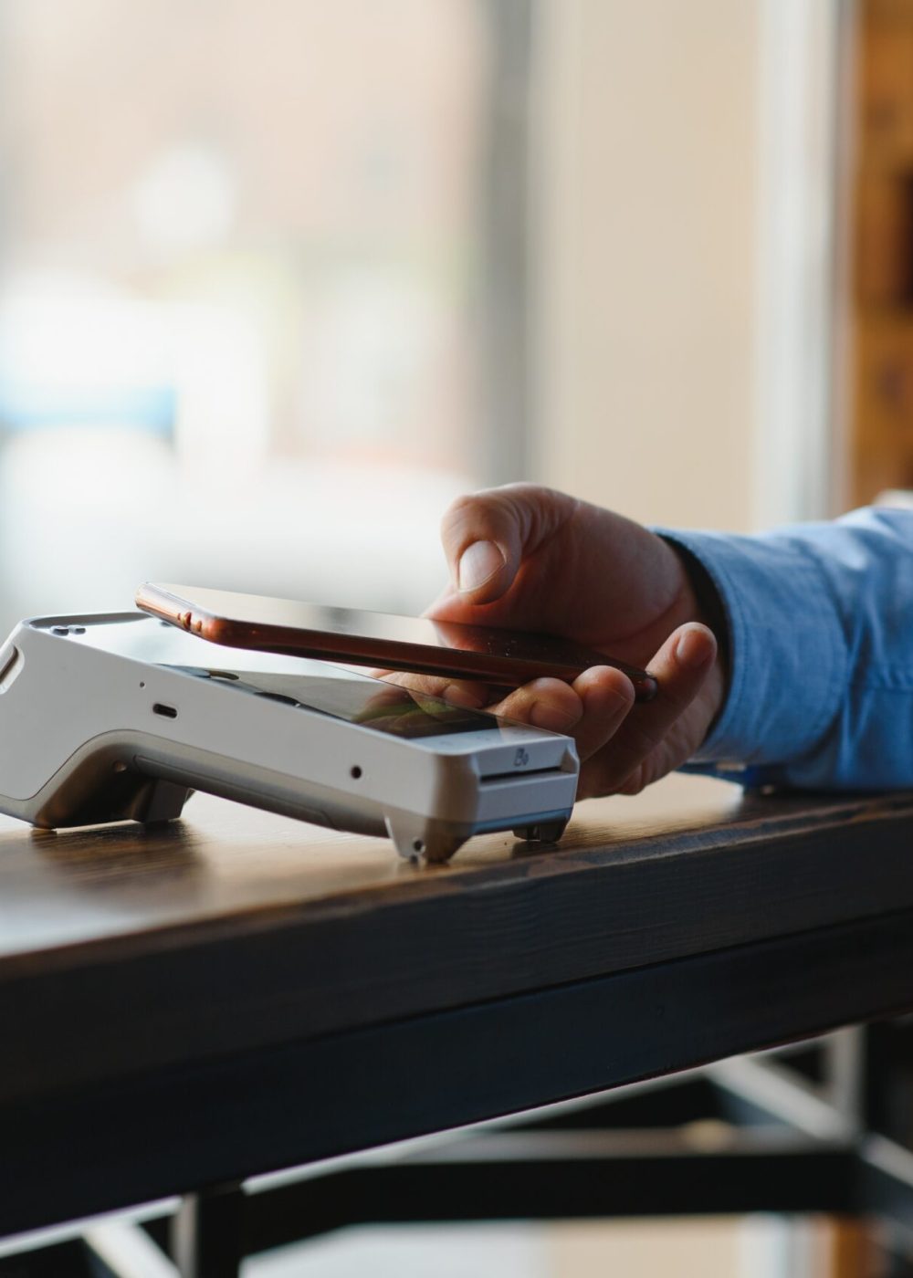 Mature businessman paying with contactless credit card with NFC technology